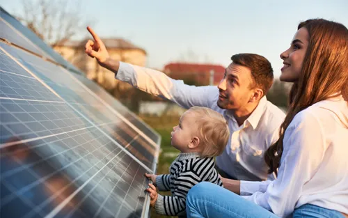 Familie blickt gemeinsam auf ein Photovoltaikmodul.