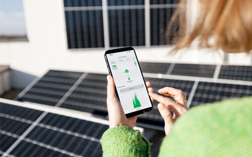 Person nutzt Überwachungs-App einer Solaranlage.